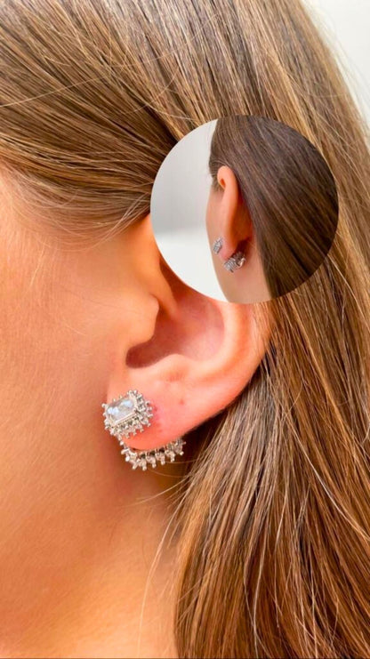  Close-up of a person's ear wearing a pair of silver, rectangular-shaped stud earrings with small dangling gems made from white tourmaline. Inset shows a detailed view of the diana earrings from a different angle.